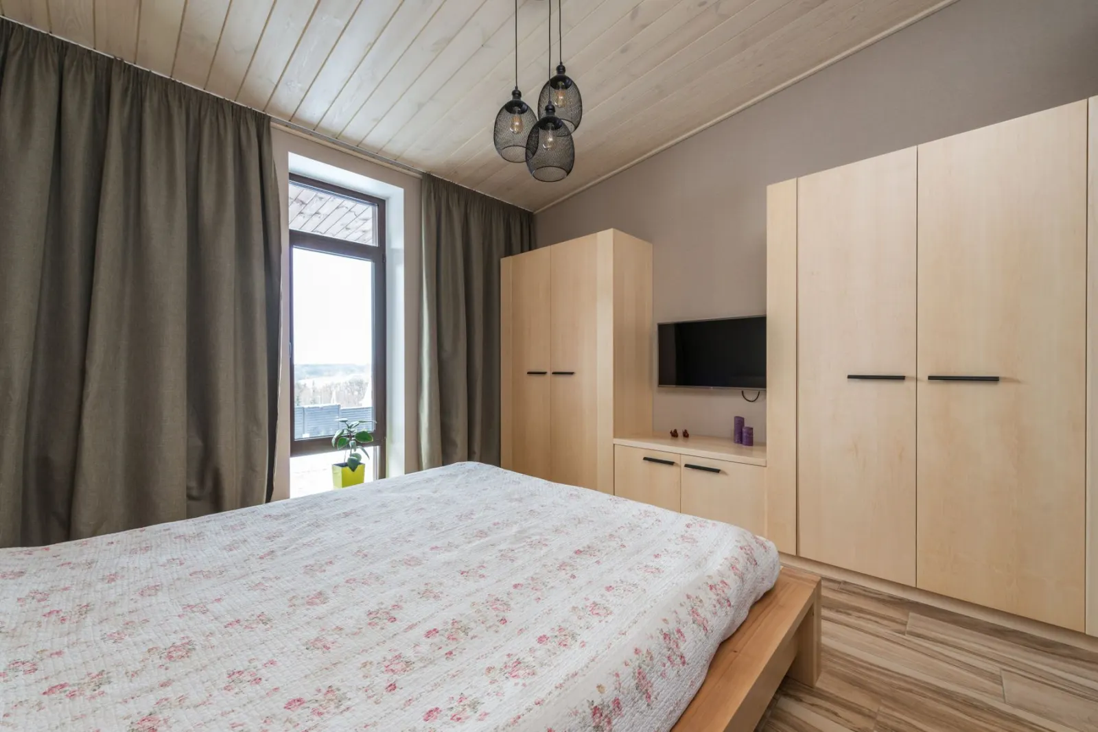 A bedroom with full-height fitted wardrobes built along one wall