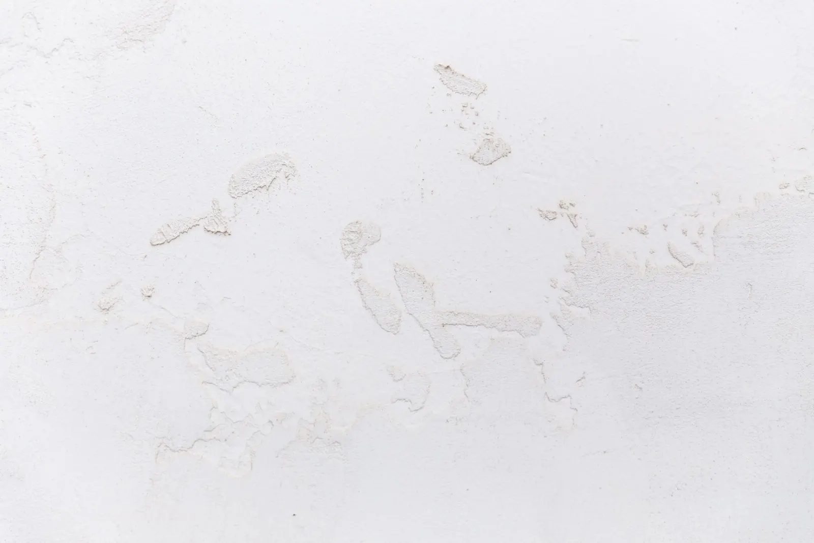 A plain painted wall meeting the floor at a clean line