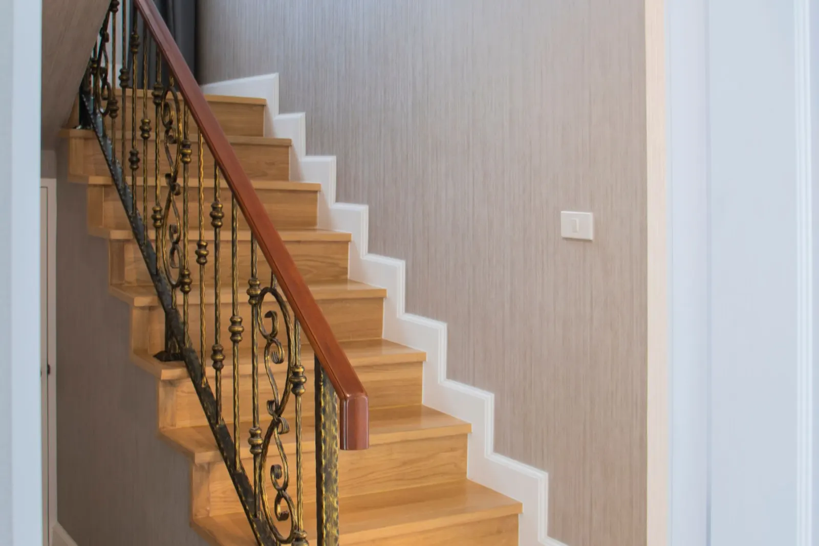 A timber staircase with a turned balustrade and handrail
